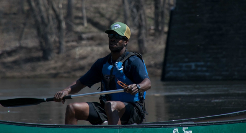 a person paddles a canoe on an outward bound veterans expedition